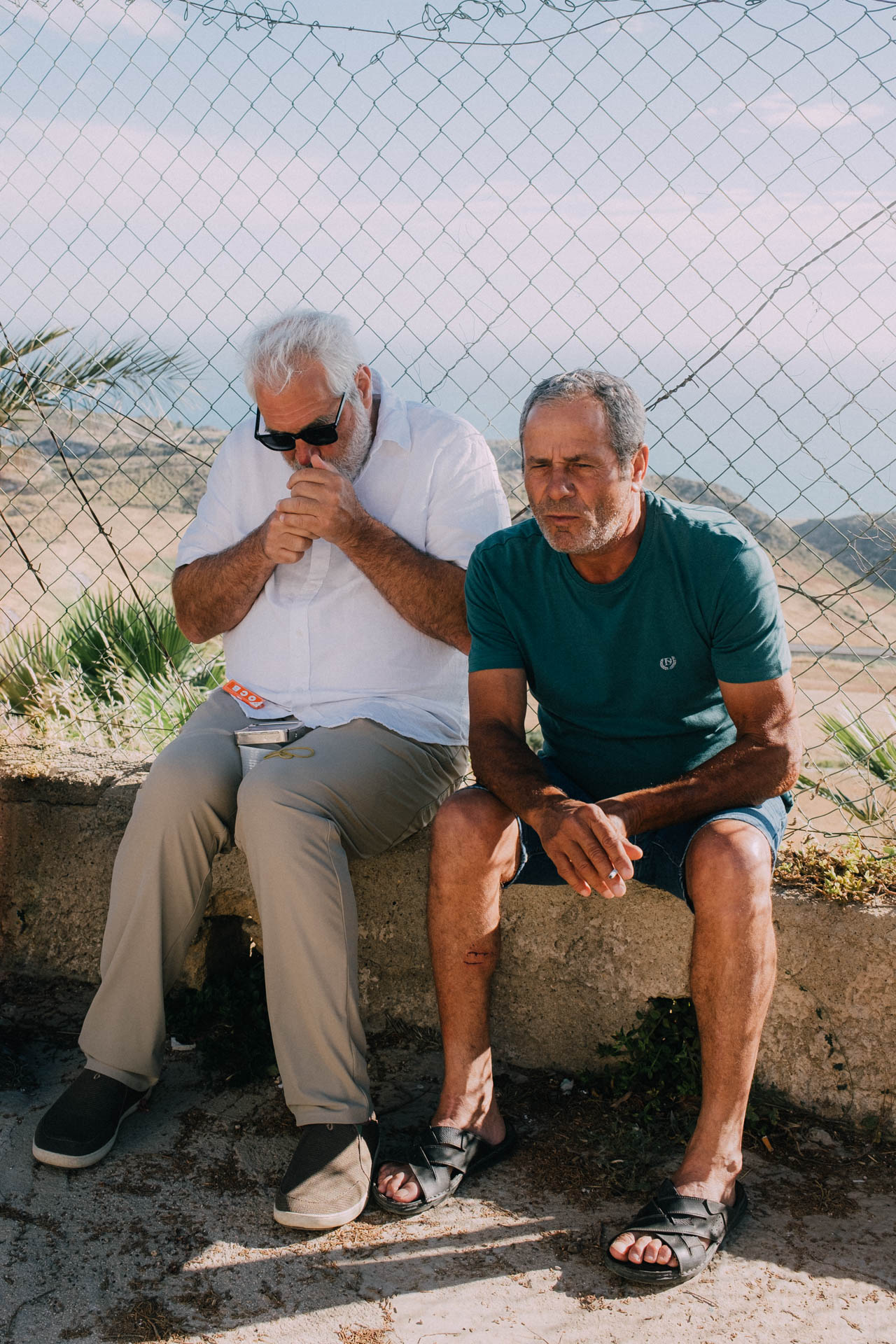 Two men taking a break during sunset near the coast of Sicily