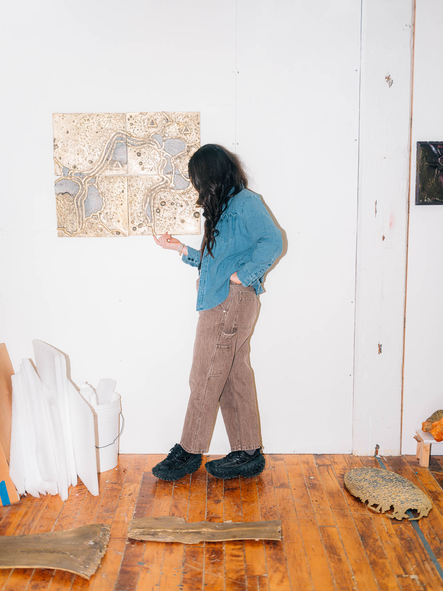 Lara Saget standing with her sculptures in her studio