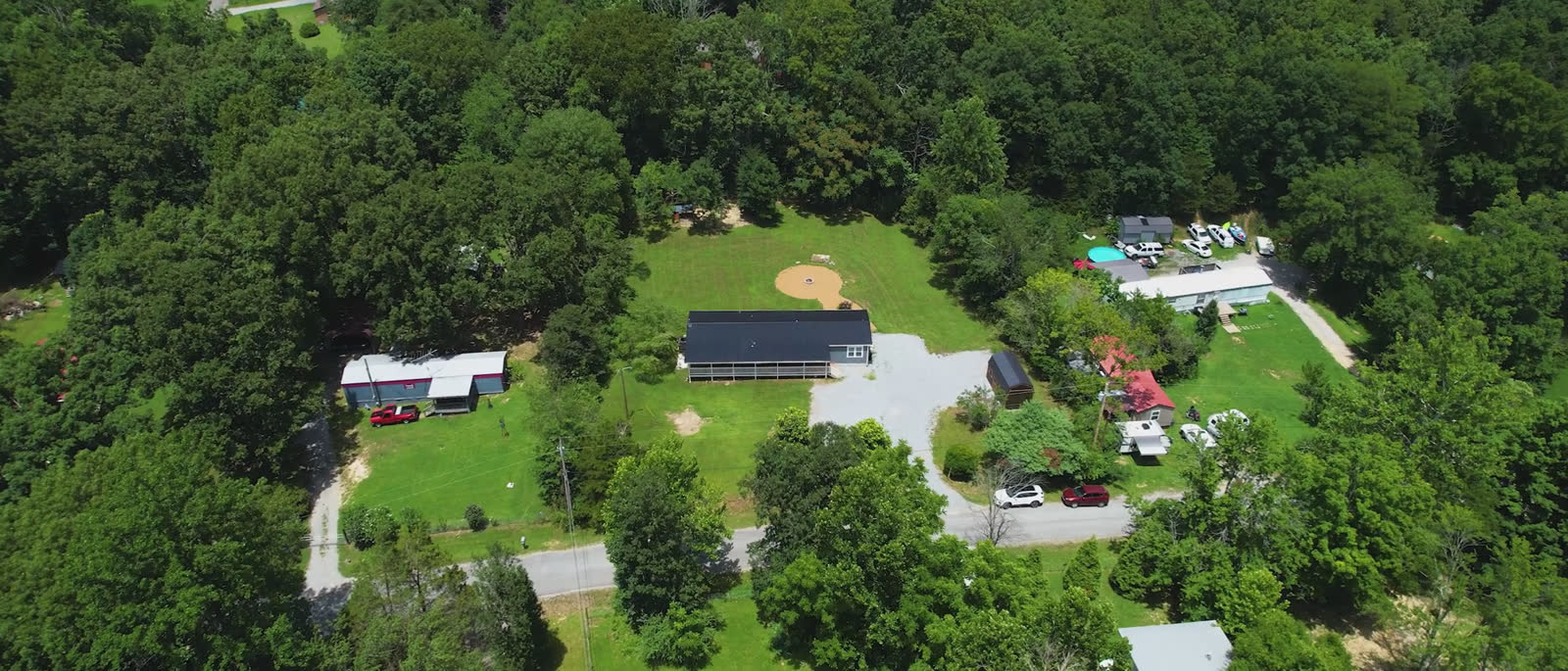 Aerial view of the home, yard, gravel drive and storage building