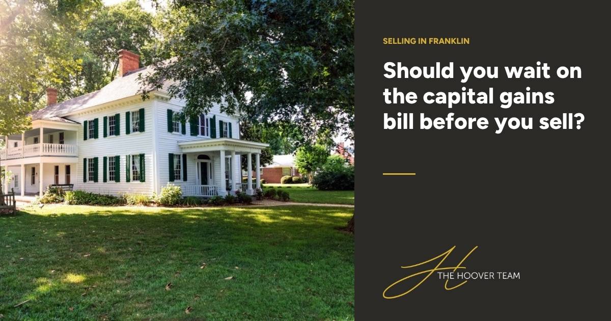 White two-story colonial home with green shutters under mature shade trees, beside the headline: Should you wait on the capital gains bill before you sell?