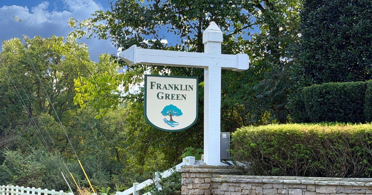 Franklin Green neighborhood sign on a white post with tree logo above a stone wall, Franklin, Tennessee