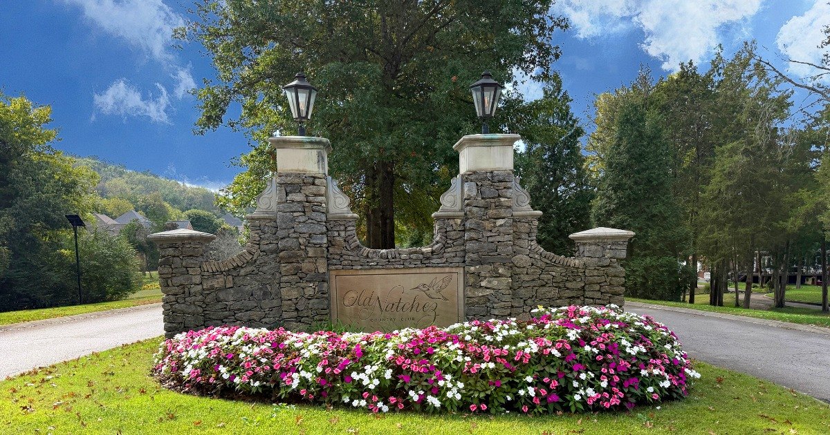 Old Natchez Country Club stone entrance sign with lanterns and flower bed, Franklin, Tennessee