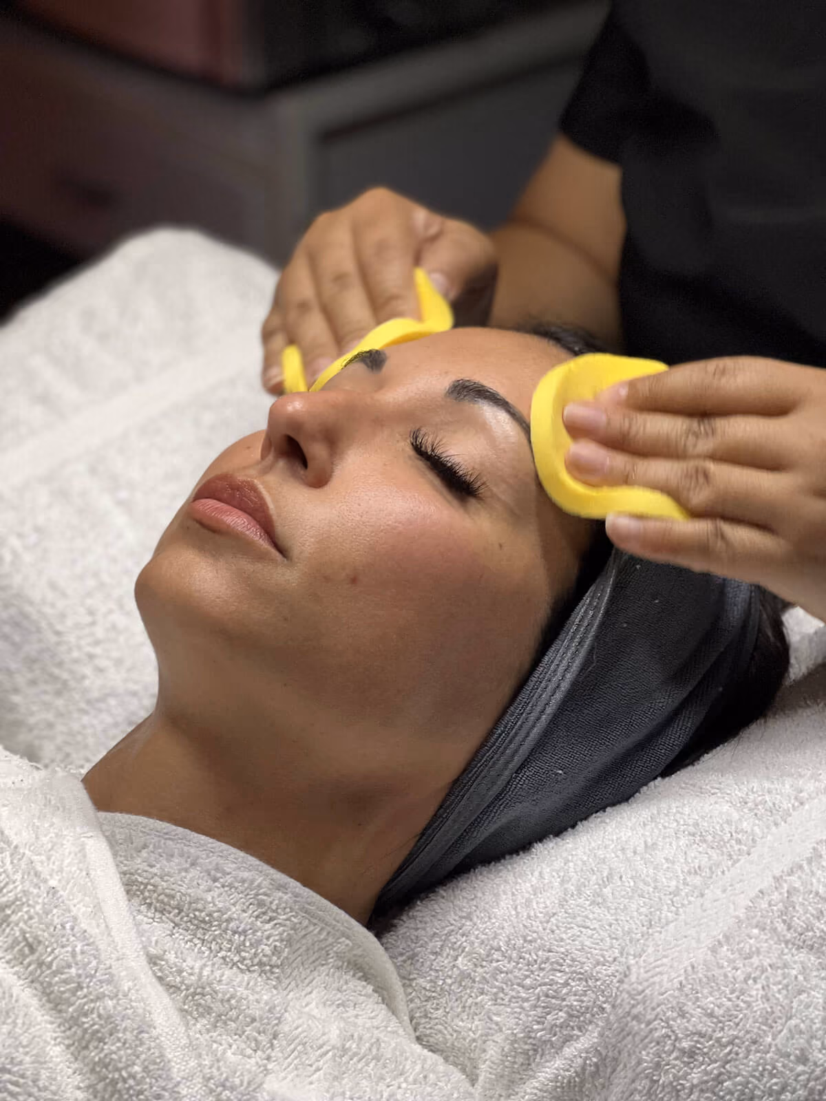 woman in a robe with her head on a pillow as she enjoys the spa