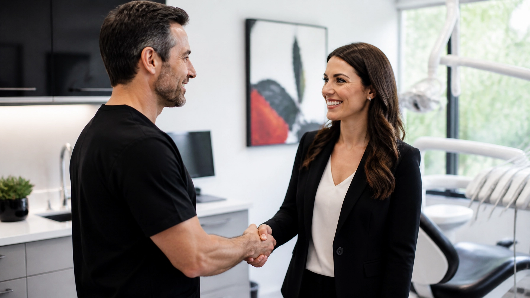 A dental practice owner shaking hands with a recruitment consultant or business partner in a modern dental office, conveying trust and successful partnership.