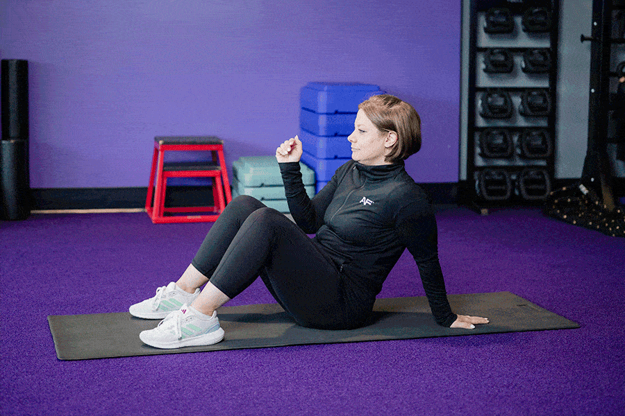 Anytime Fitness Coach demonstrating hip mobility exercises, including the crab reach.