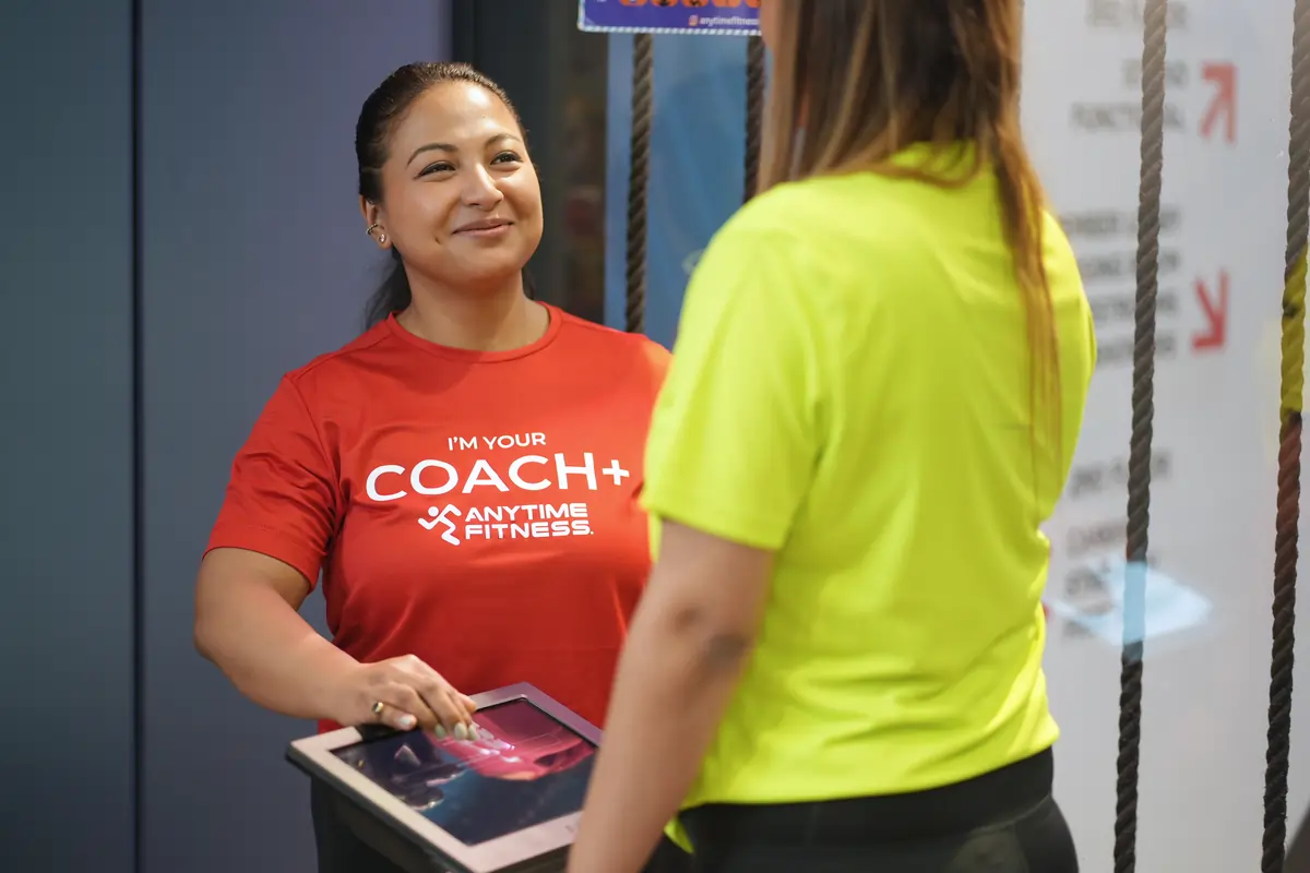 A close-up of digital fitness tracking screens and equipment interfaces highlights Anytime Fitness’s blend of expert coaching and technology to support real progress.