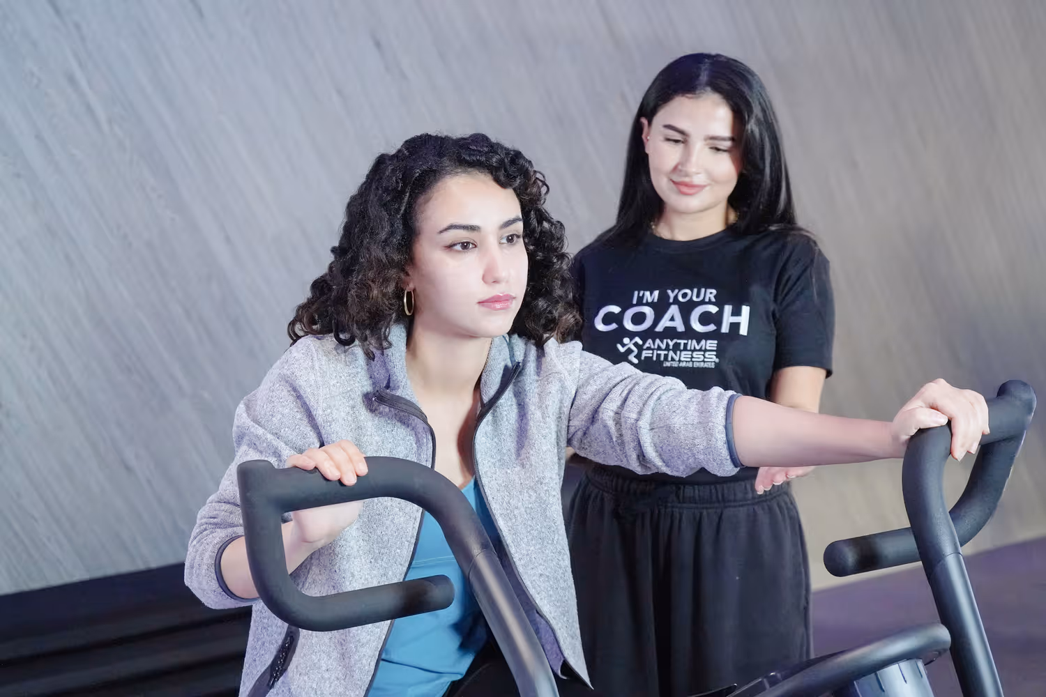 امرأة تتمرن على جهاز الكارديو تحت إشراف مدربة من Anytime Fitness
