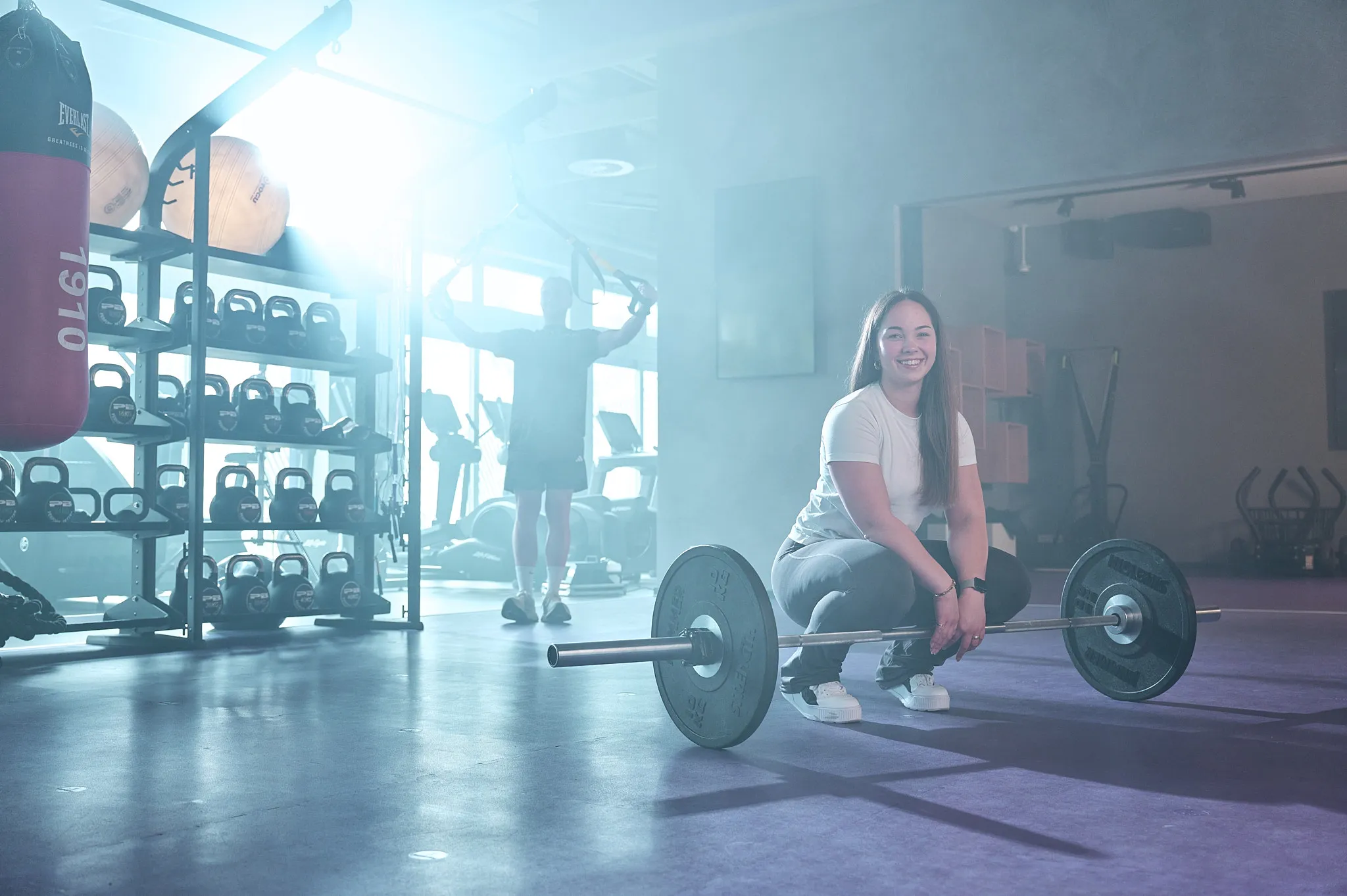 Anytime Fitness Deutschland Promotion-Hero-Banner mit einer Frau, die einen Medizinball hält, und dem Text 'Mehr für deine Mitgliedschaft'.