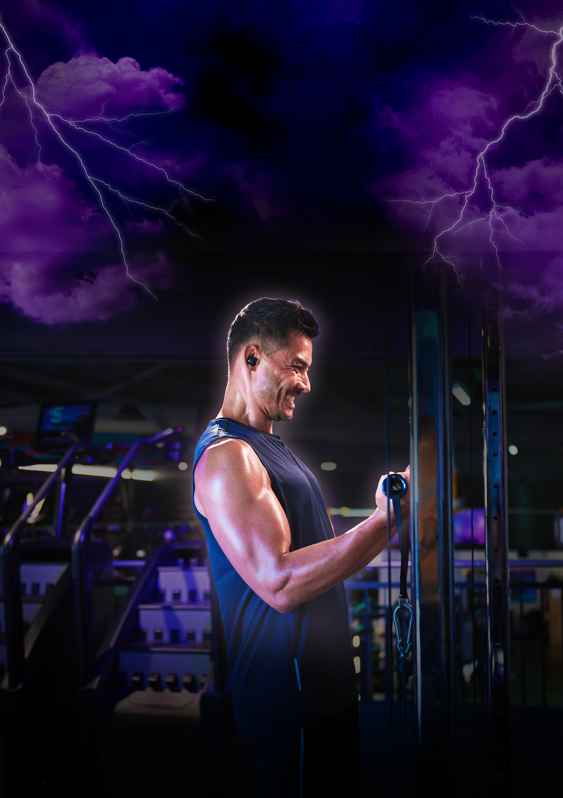 A personal trainer smiles while supervising a woman performing a dumbbell chest press on a weight bench in a modern gym.