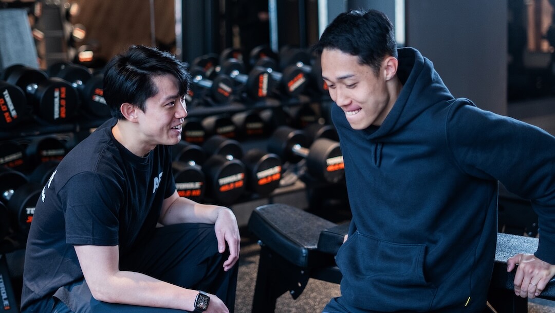 Anytime Fitness 私人教練在健身室內親切指導會員