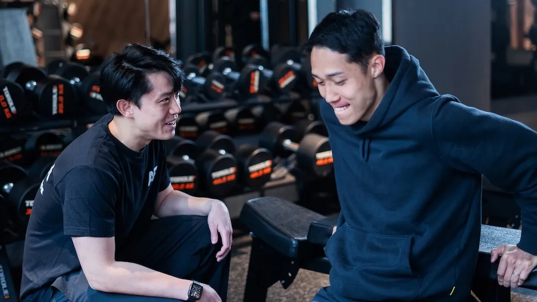 Anytime Fitness 教練在自由重量區指導男會員