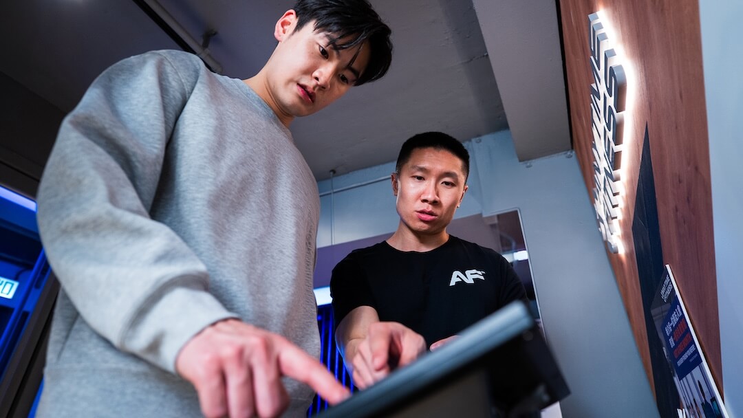 教練協助會員操作 Anytime Fitness 數碼健身設施