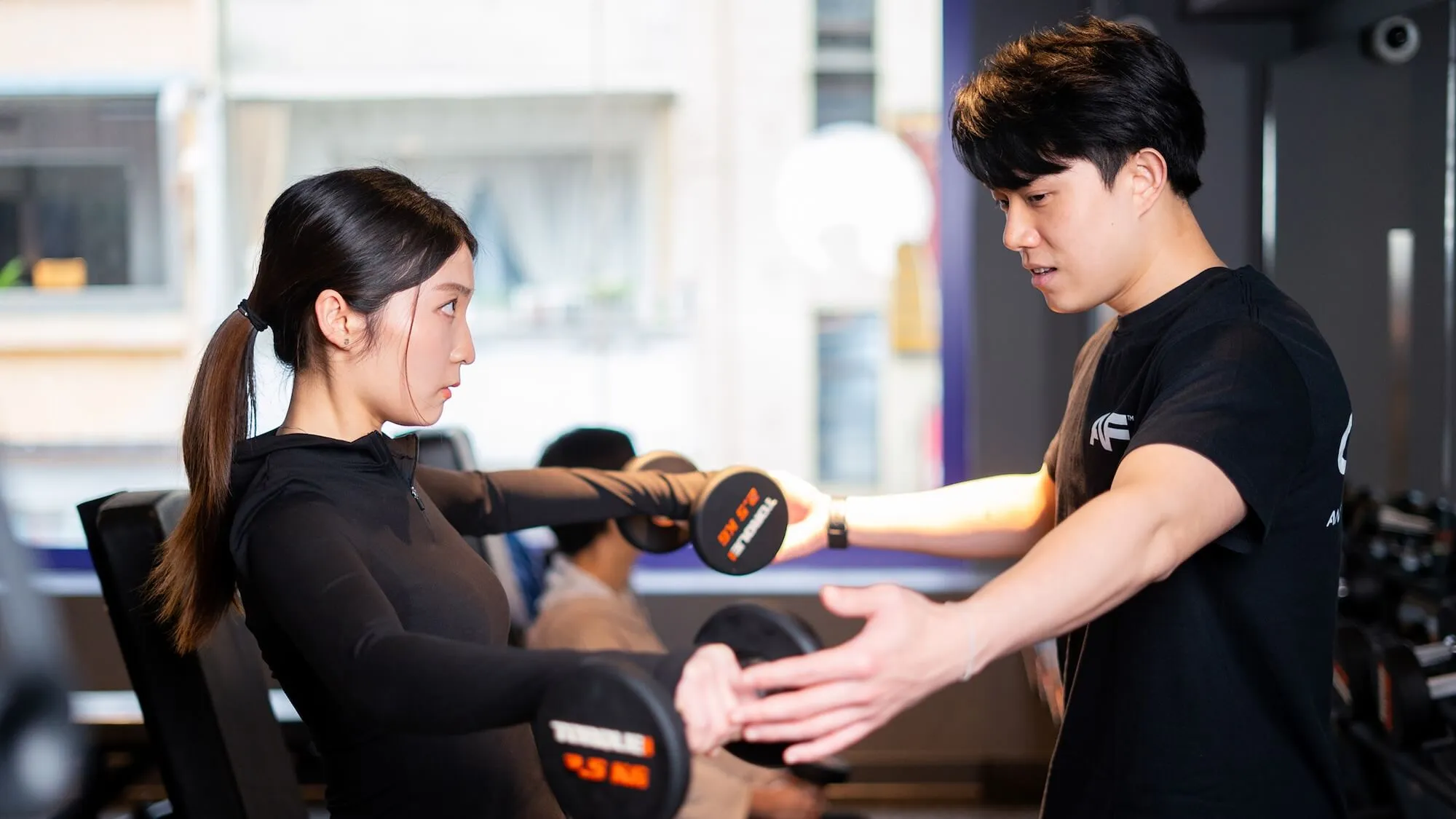 Anytime Fitness 私人教練指導會員進行啞鈴訓練