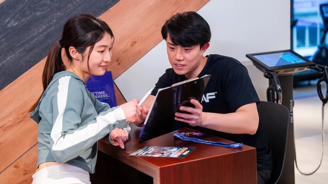 Anytime Fitness 教練與會員進行一對一健康及訓練諮詢