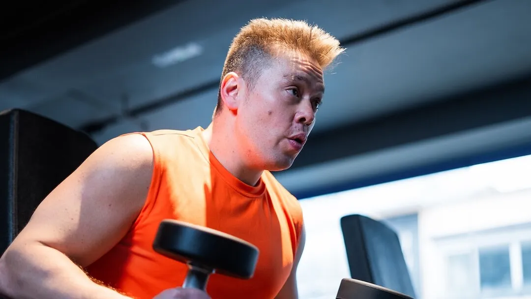 男會員在健身室專注進行啞鈴重訓