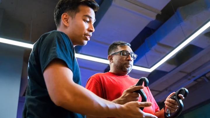 Two men playing a video game using motion controllers in a modern indoor space.