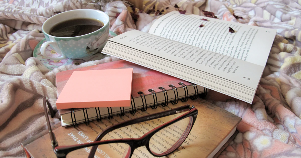 Printed medical research papers and reading glasses on a desk