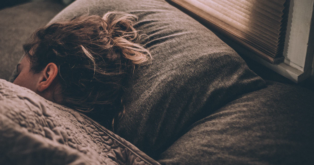 Woman resting in bed in morning light