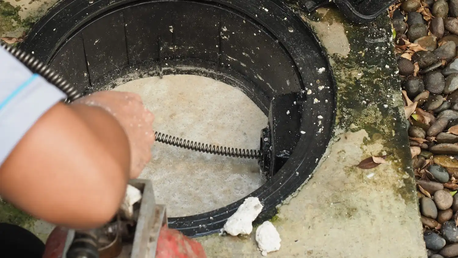 Image of a man working on kitchen plumbing