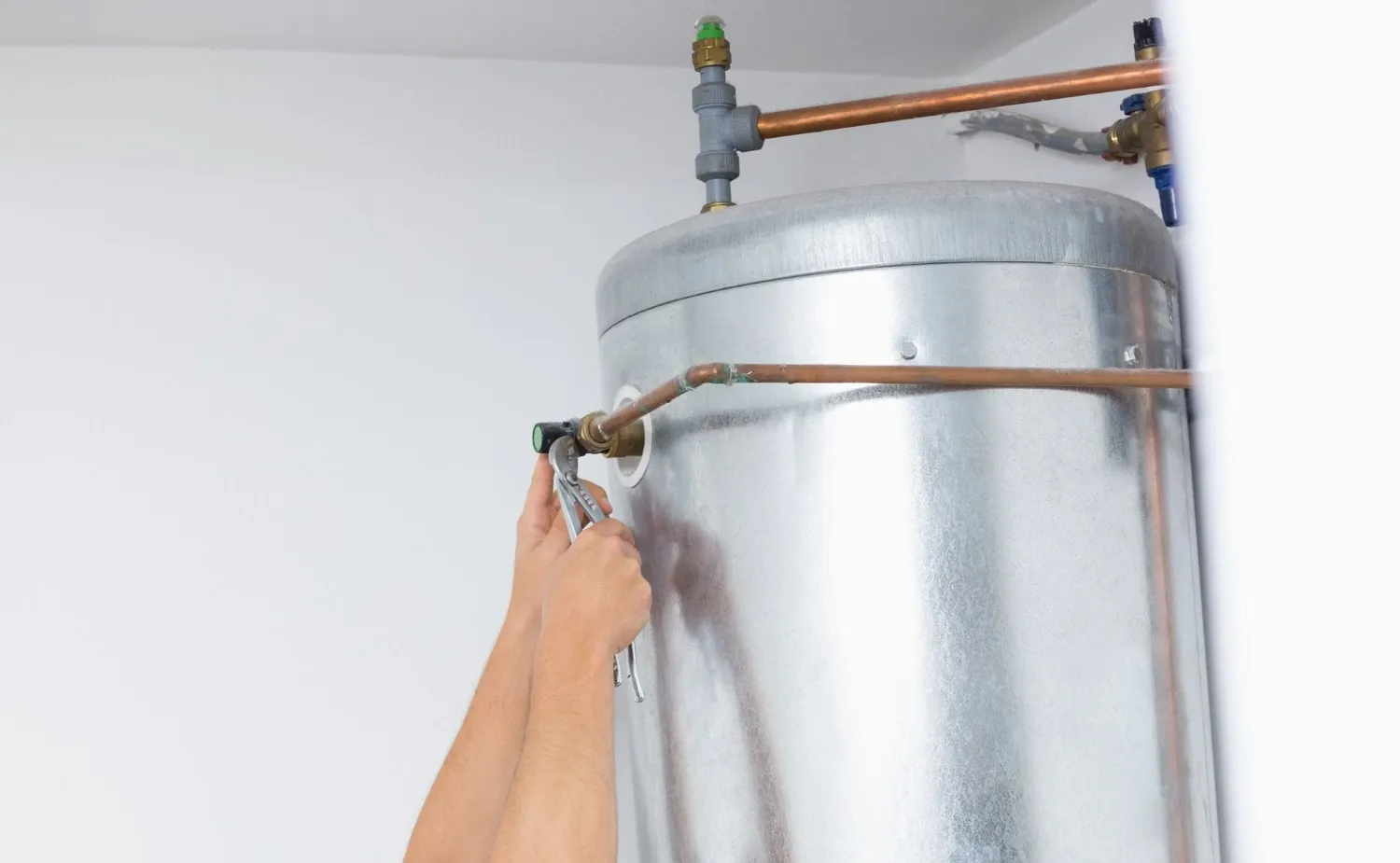 Image of a man working on kitchen plumbing