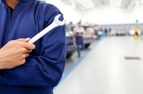 Image of a man working on kitchen plumbing