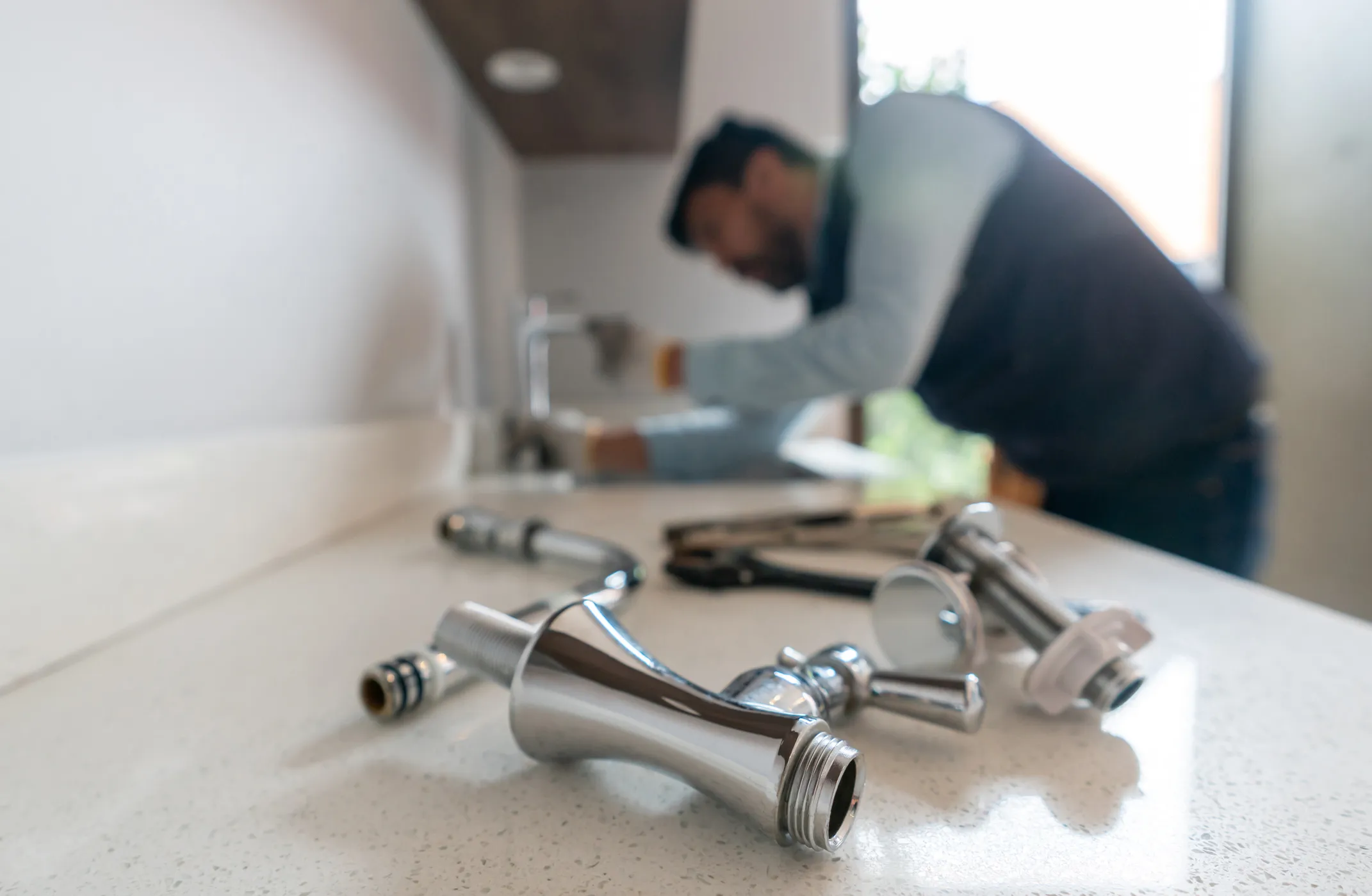 A plumber repairing a sink using tool 