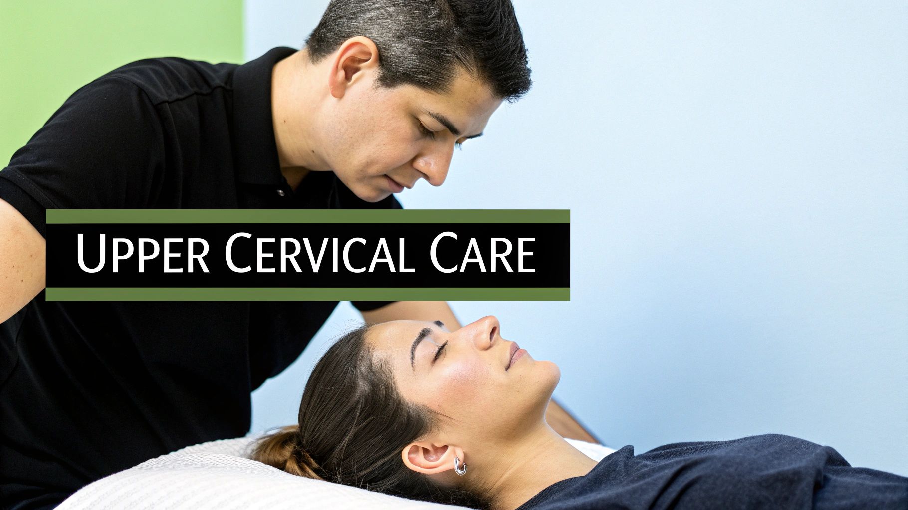A male practitioner performs upper cervical care on a female patient lying on a treatment table.