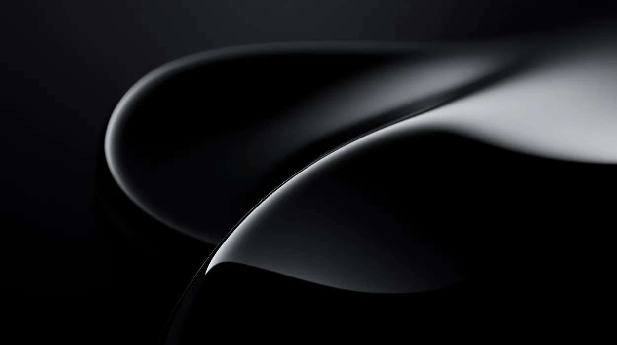 Glossy black curved shapes with smooth reflections on a dark background.