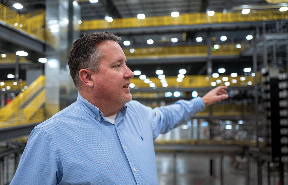 Business owner pointing inside a factory.
