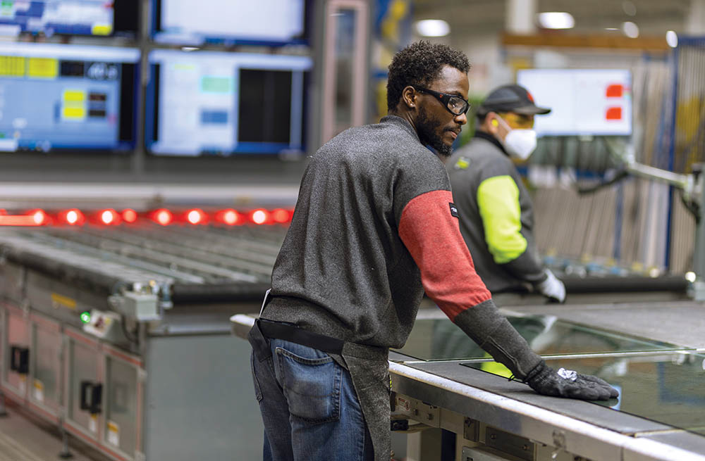 A team leader inspecting product on an assembly line at Cardinal Glass in North Dakota.