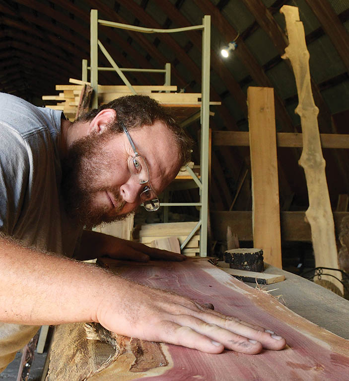 Woodworker looking at a wood plank for a project.