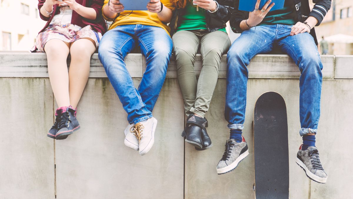 Quatre adolescent assis sur un muret