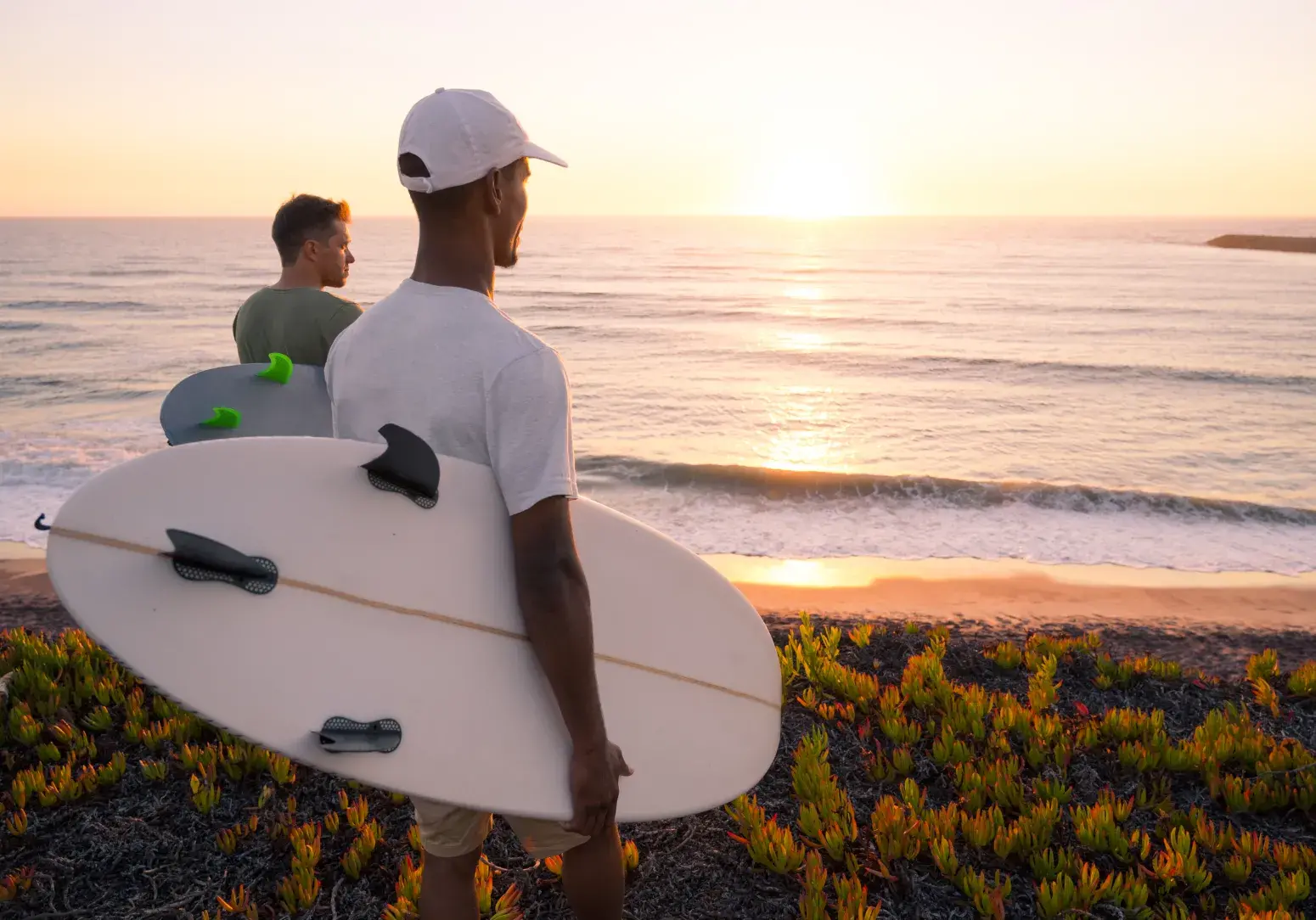 Dos surfistas de pie en un acantilado al atardecer, mirando el océano. Si estás armando una colección visual o necesitas que todos los textos tengan un estilo uniforme, puedo ayudarte a pulirlos. ¿Quieres que los revise juntos?