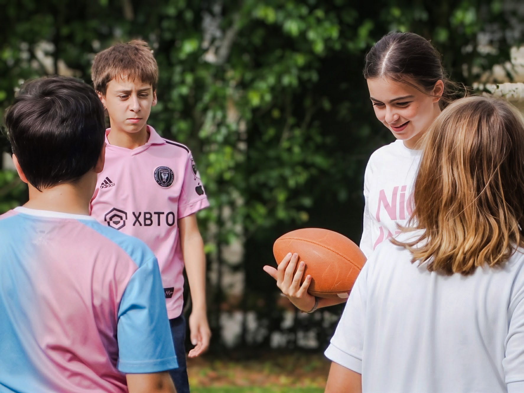 Gordon students playing football together outdoors