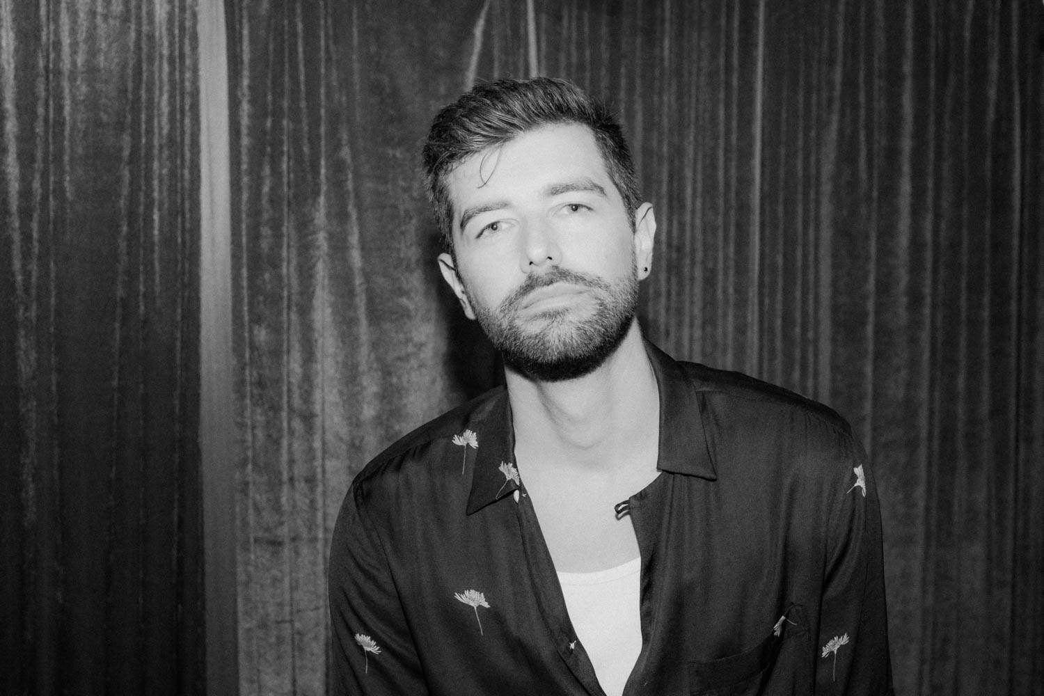 Portrait of Jonathan Grado in a daffodil shirt using heightened look flash photography. Black and white velvet.