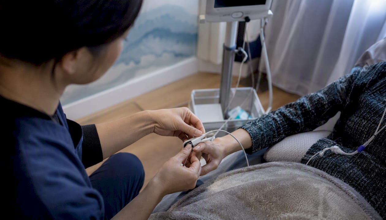 Nurse applying blood pressure cuff during ketamine dosing