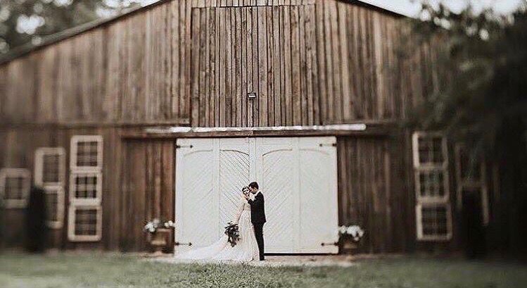 wedding couple in front of barn doors at Meadow Hill Farms in Nashville