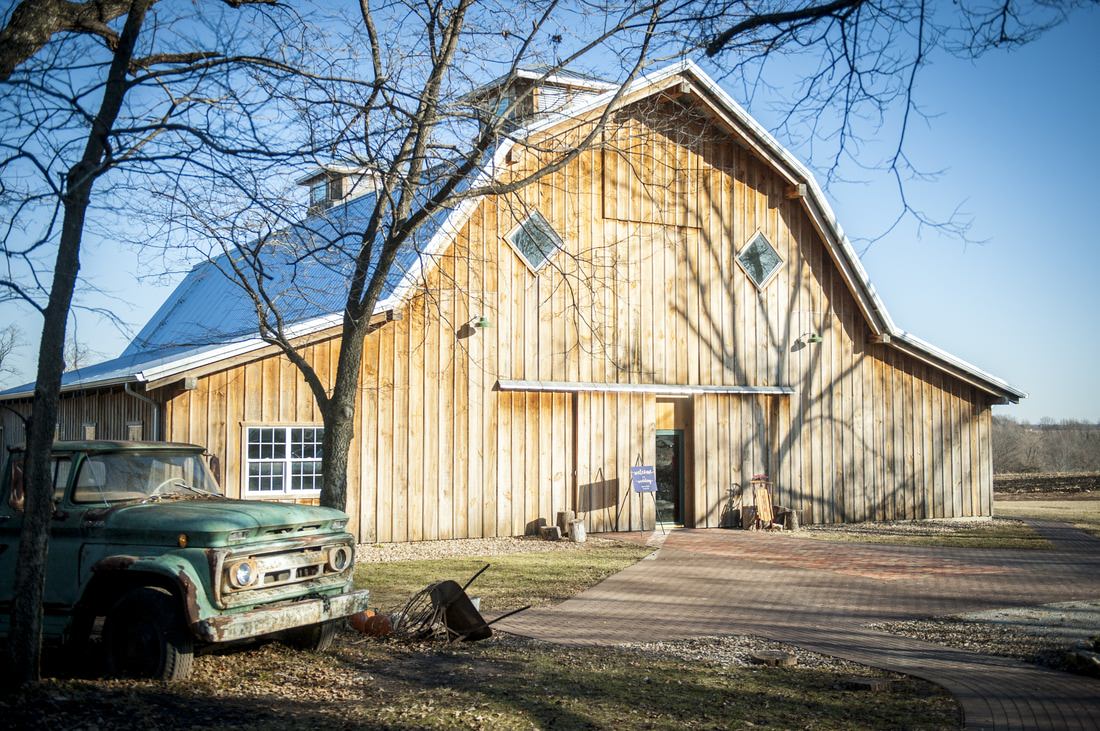rustic barn structure in the fall at The Barn at Schwinn Farms with a classic teal-green pickup truck