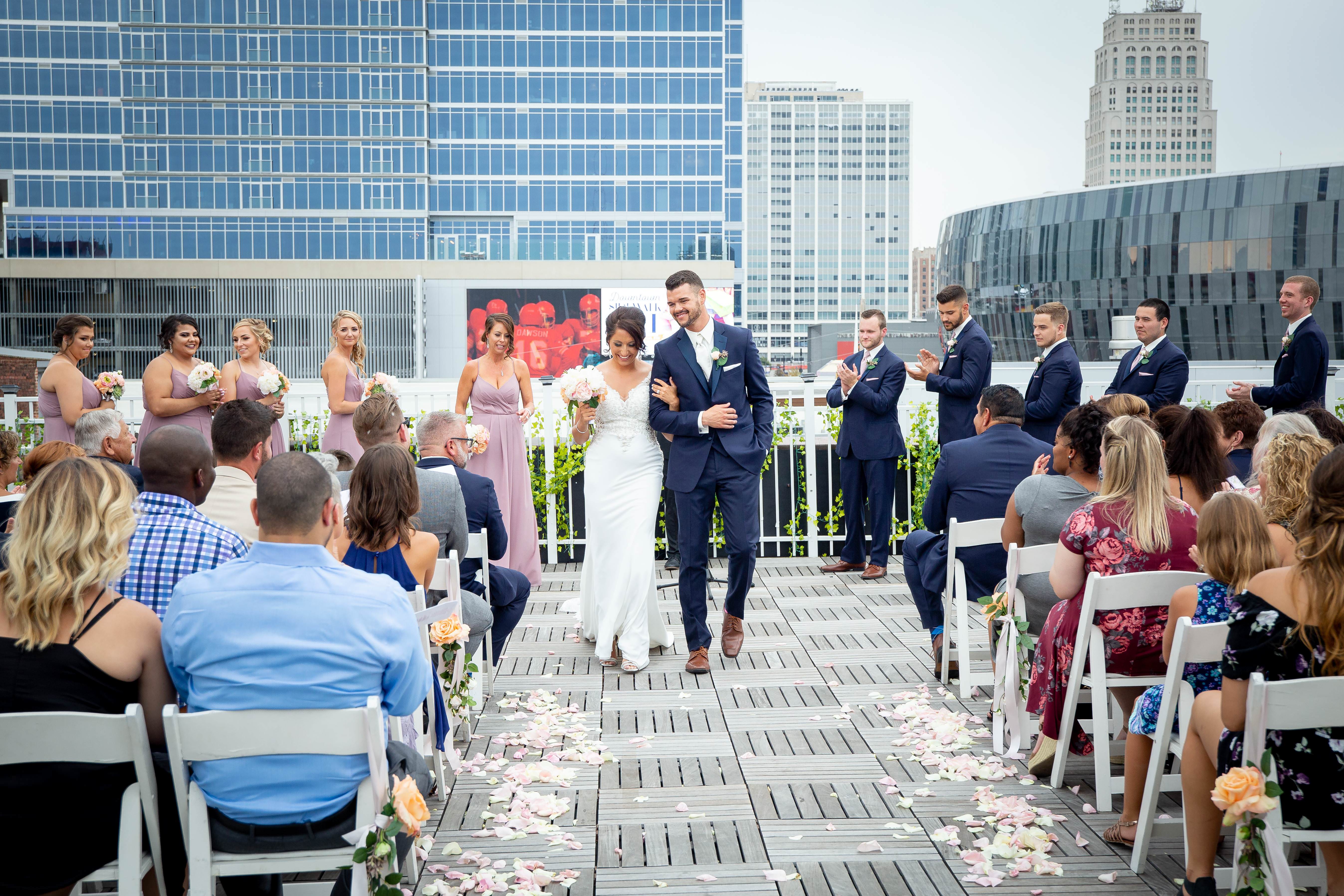 a bride and groom doing their recessional walk down the aisle at The terrace on Grand in downtown Kansas City