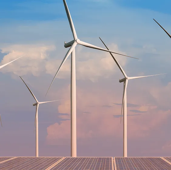 A group of windmills and solar panels are in the same image