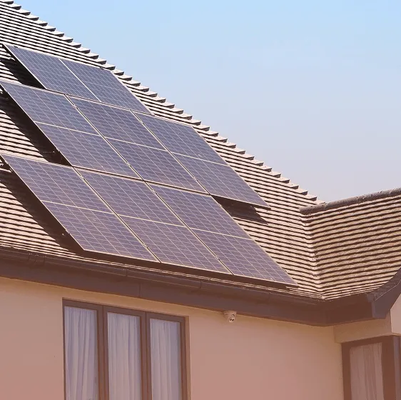 Solar panels are installed on the top roof surfaces of a house