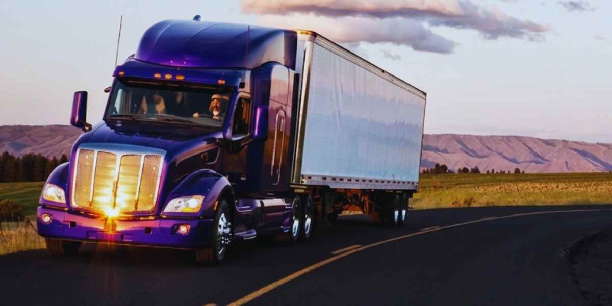 Purple truck driving on road in mountain west USA.