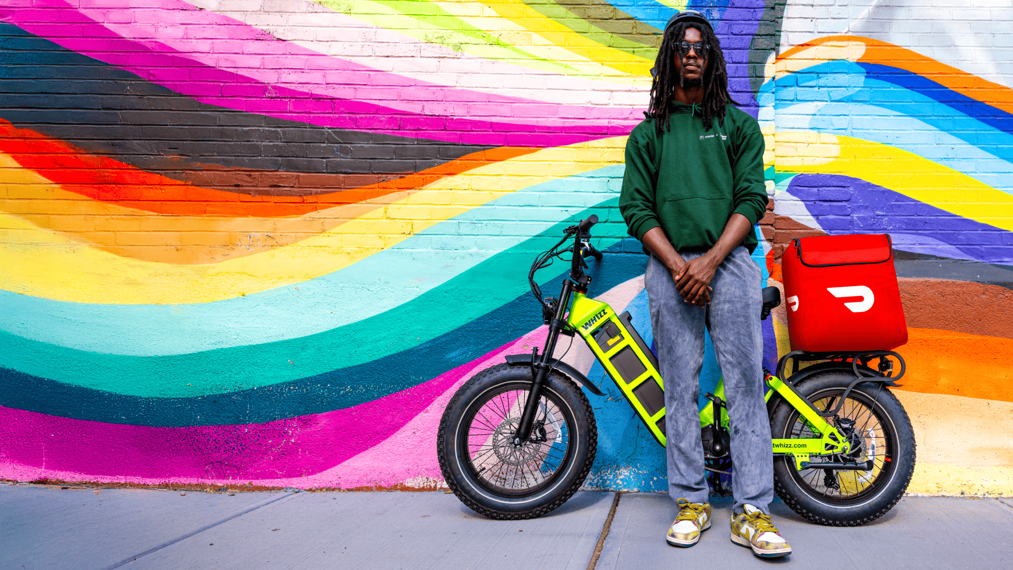 DoorDash delivery rider standing with Whizz electric fat-tire e-bike