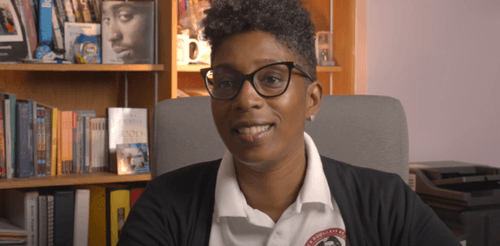 Principal speaking in office with bookshelves in background