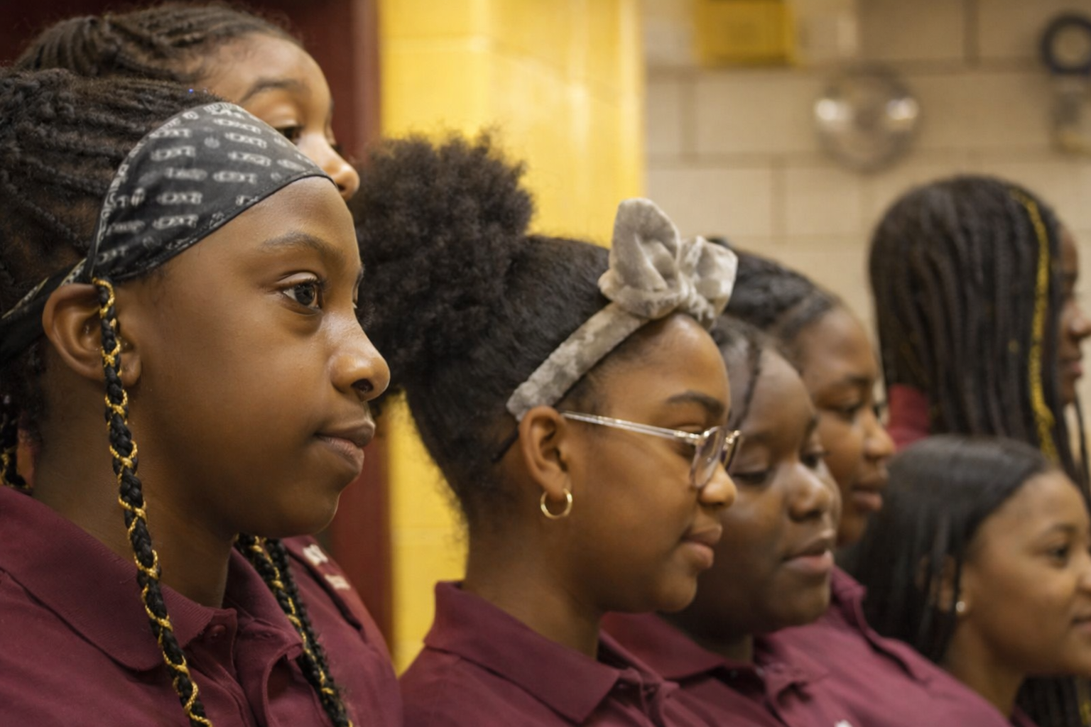 Students in school uniforms standing attentively in a row