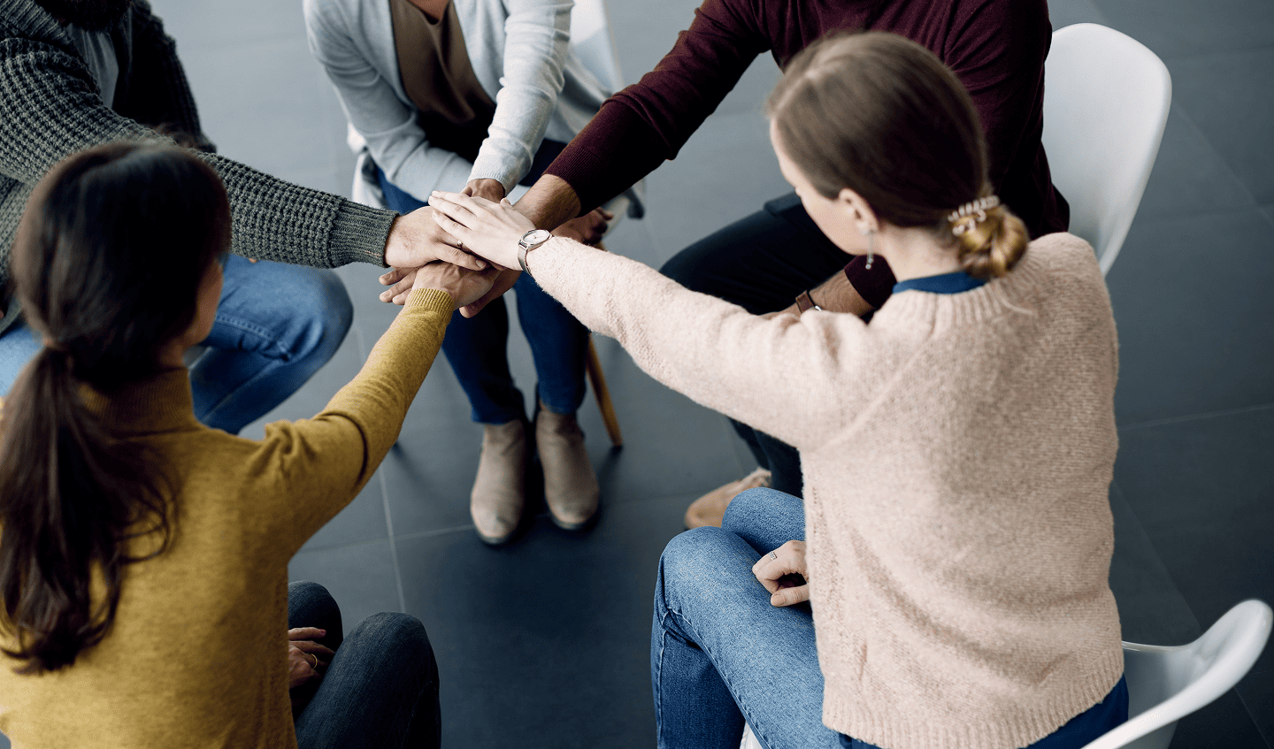 A group of people holding their hands together