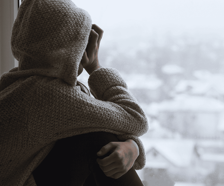 Desperate woman looking at the window