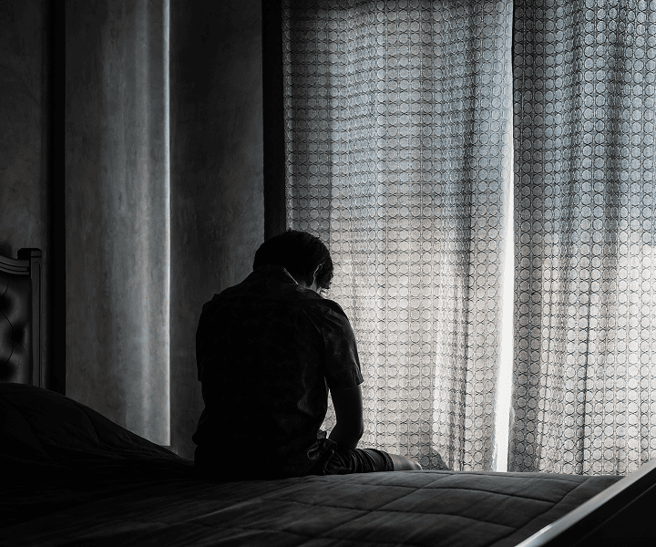 Desperate man sitting at the bed