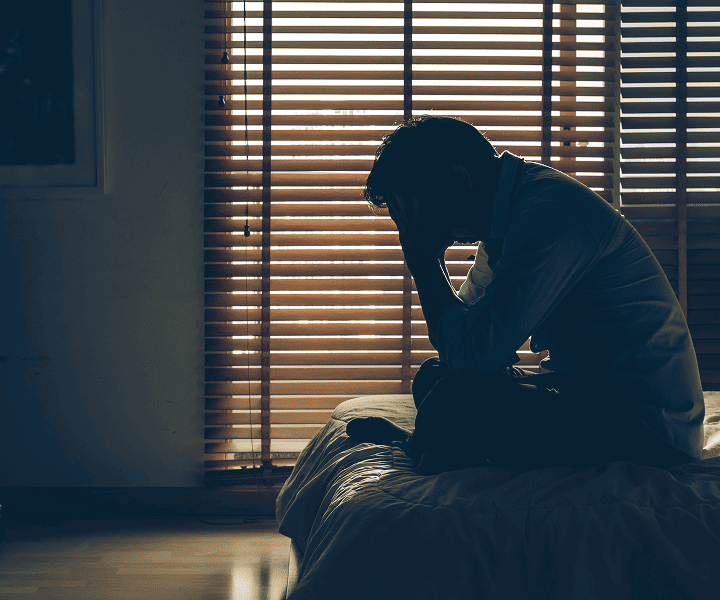 Desperate man sitting on the bed