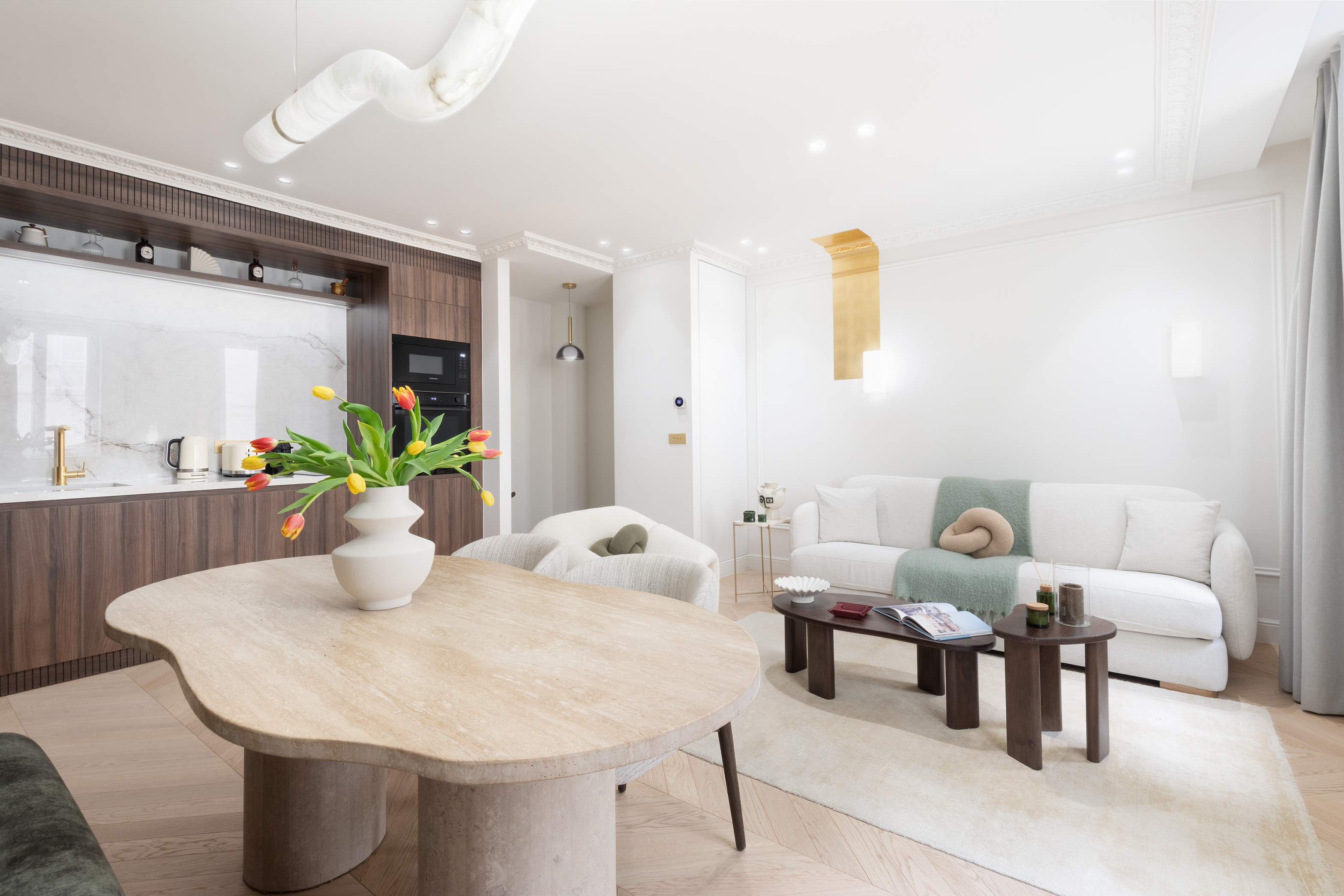 Salon élégant avec canapé et moulures haussmanniennes – Appartement de luxe Maison Galante au Louvre, Paris.